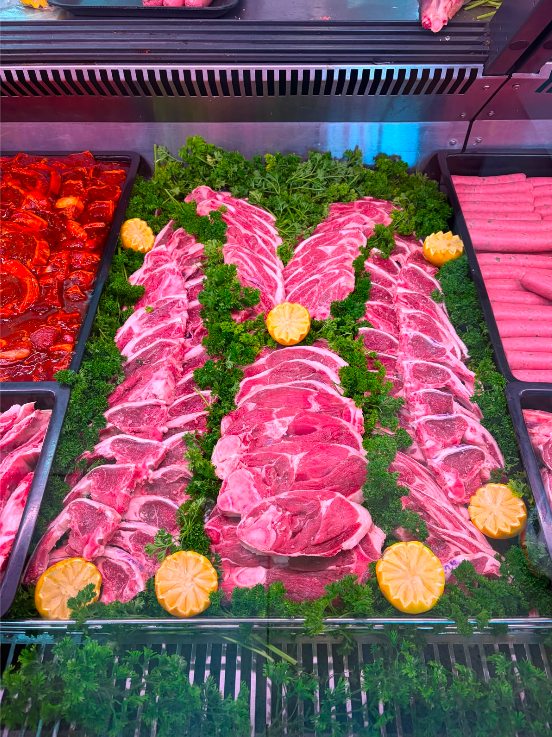 Fresh lamb display with garnish at Tops Halaal Meat Market